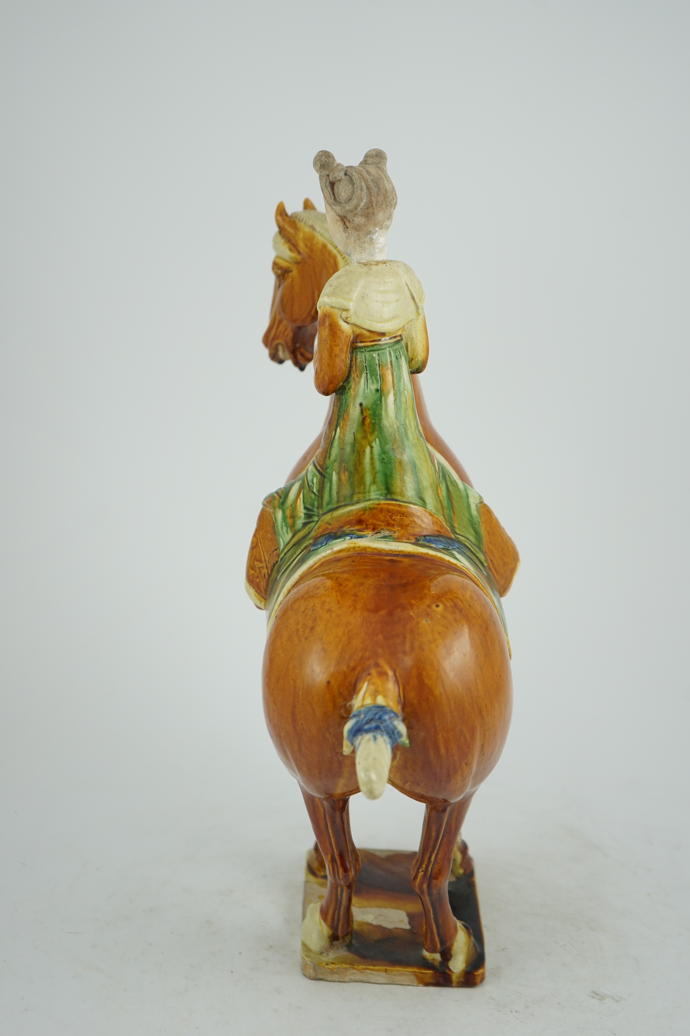 A Chinese sancai glazed group of a horse and female rider, Tang or later